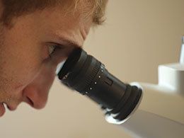 student looking through microscope